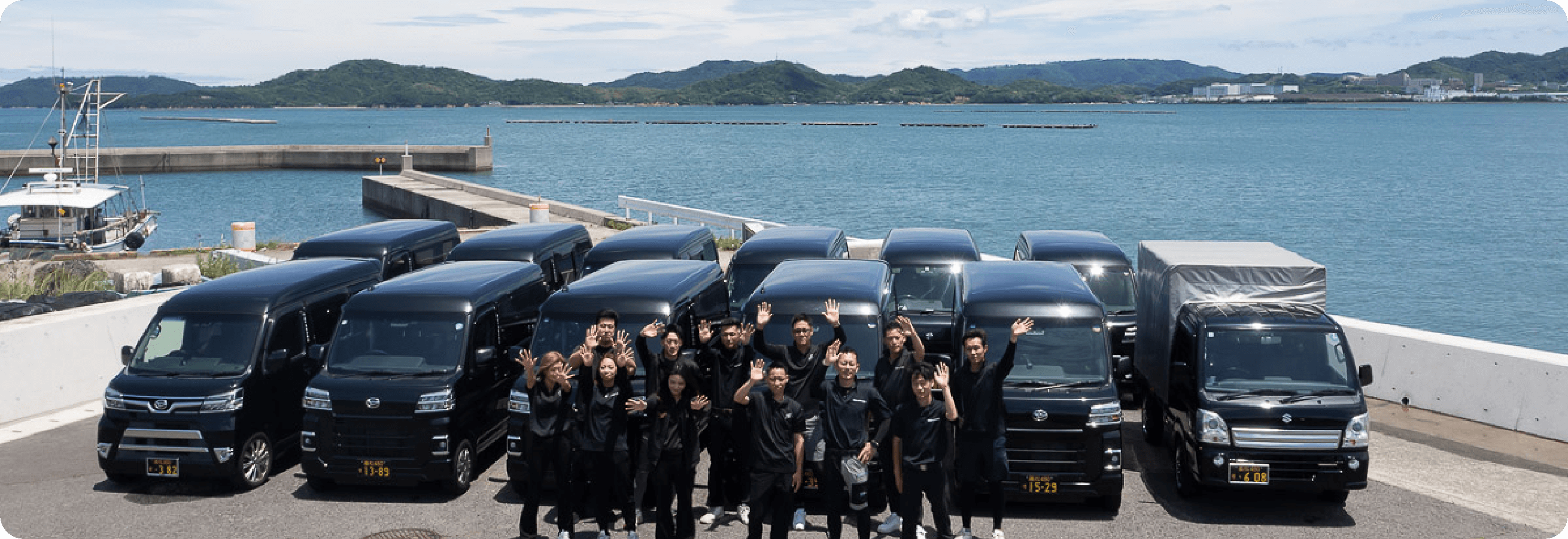 従業員と軽自動車の集合写真