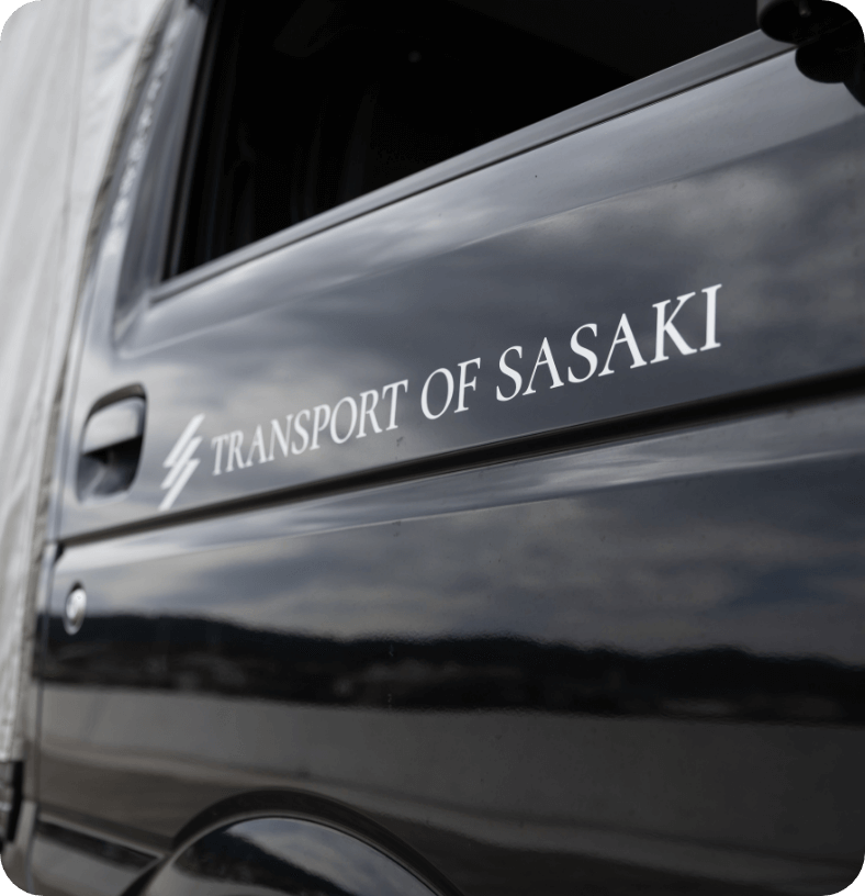 トラックの運転席でメモをとる男性